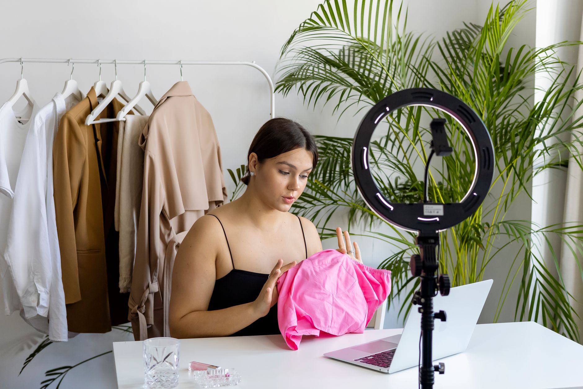 Fashion vlogger presents stylish outfit during a live session indoors.